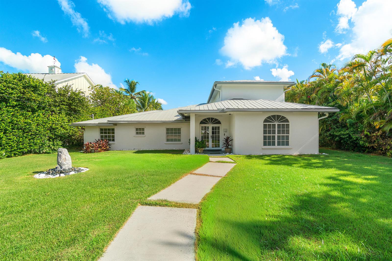 An aerial view shows a waterfront property with a long dock and a swimming pool — 5447 Center Street, Jupiter FL 33458, JUPITER, FL