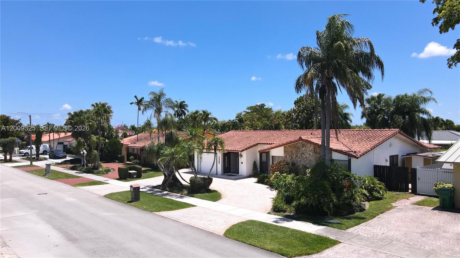 A single-story house with a red tile roof and stone facade sits along a street — 13300 SW 21st St, Miami FL 33175, MIAMI, FL