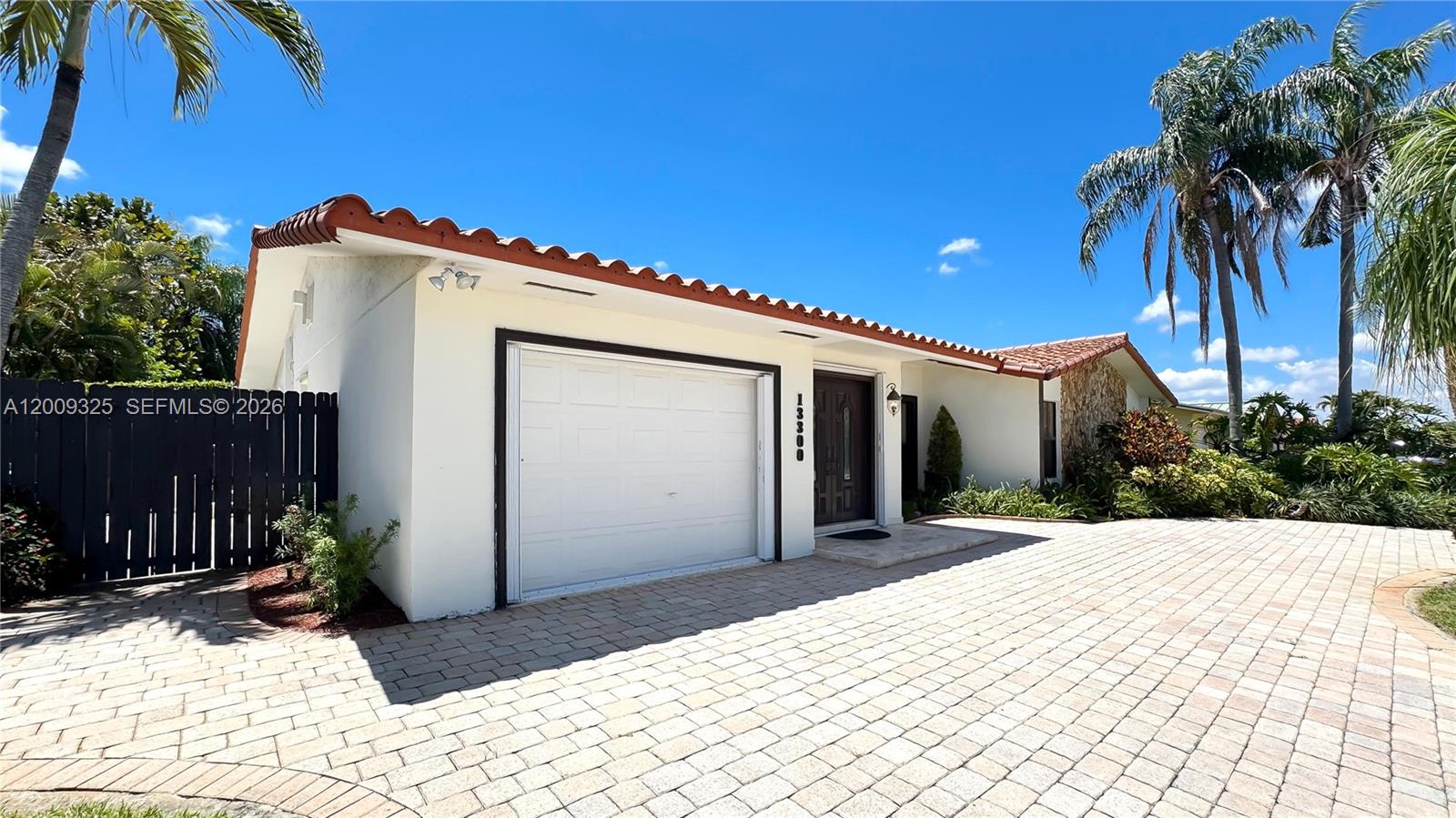 A single-story house with a white stucco exterior, tile roof, and a paved driveway — 13300 SW 21st St, Miami FL 33175, MIAMI, FL