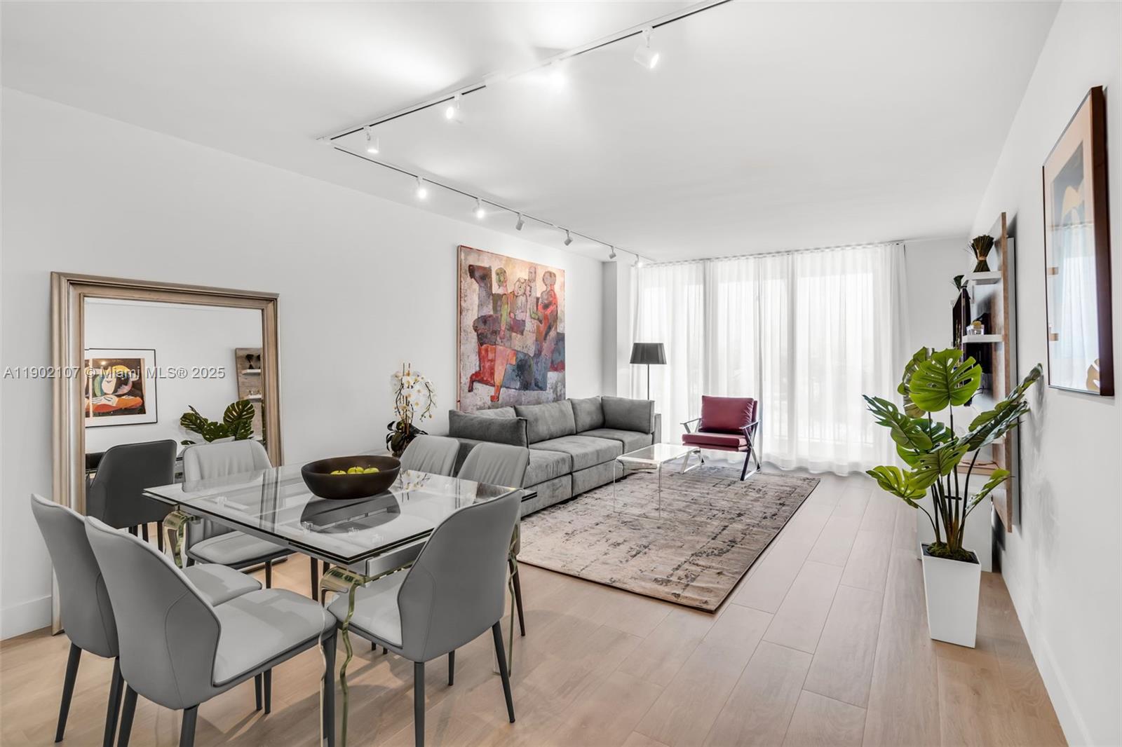 A modern living and dining area features a glass table, gray sofa, and track lighting — 1500 Ocean Dr # 1109, Miami Beach FL 33139, MIAMI BEACH, FL