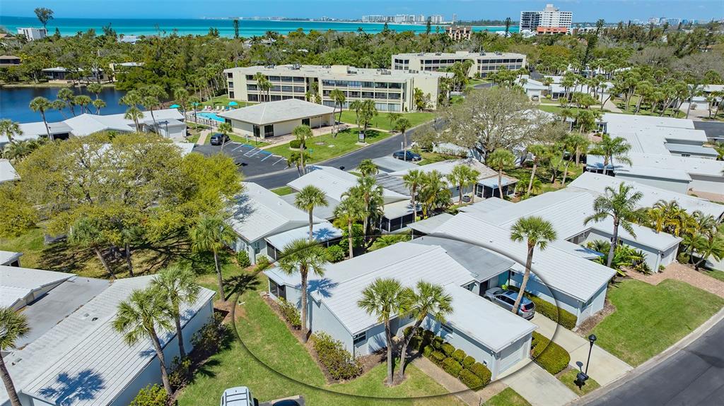 An aerial view of a single-story residential unit with a white roof and palm trees — 119 WHISPERING SANDS CIRCLE UNIT V36, SARASOTA, FL