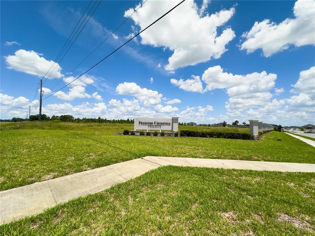 A single-story house with light blue siding, a stone entryway, and a three-car garage — 9332 SW 58TH CIRCLE, OCALA, FL