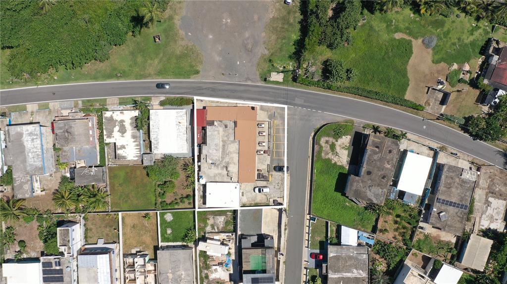 An aerial view shows a commercial building with a parking lot surrounded by residential properties — Km 3.3 CARR 684, BARCELONETA, PR
