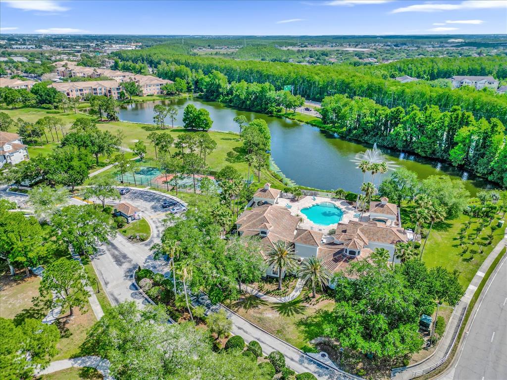An aerial view of an apartment complex featuring a clubhouse, swimming pool, and lake — 13803 FAIRWAY ISLAND DRIVE UNIT 1626, ORLANDO, FL