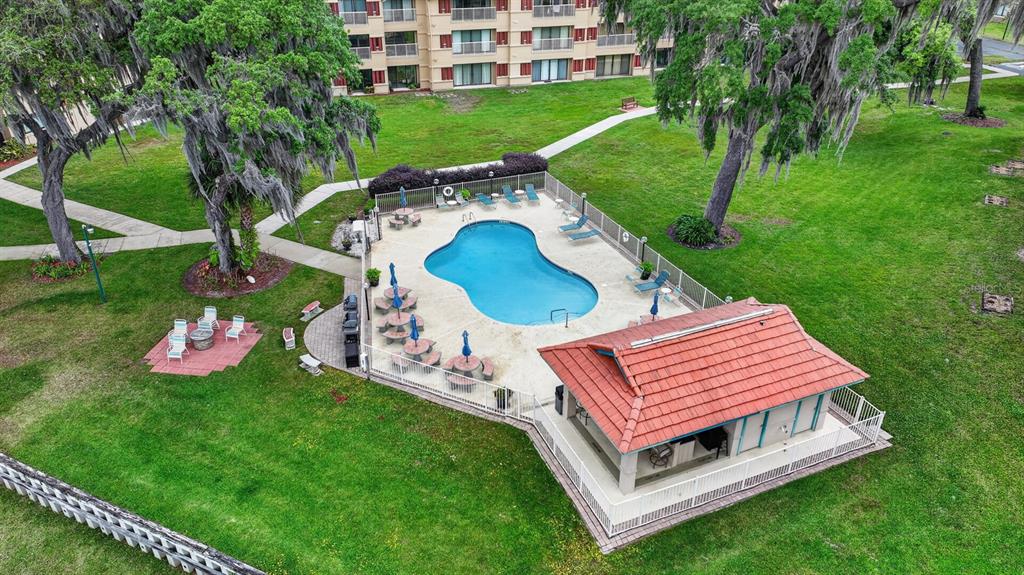 An aerial view shows a swimming pool, a covered pavilion, and patio furniture on grass — 99 BROAD RIVER PLACE UNIT 2105, WELAKA, FL