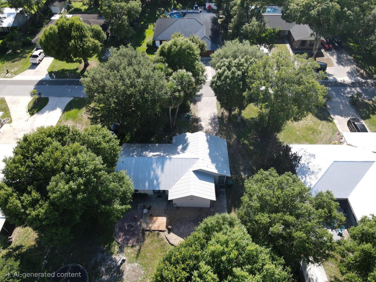 An aerial view shows a house with a metal roof surrounded by trees and lawns — 1396 SW 19th Terrace, Okeechobee FL 34974, OKEECHOBEE, FL