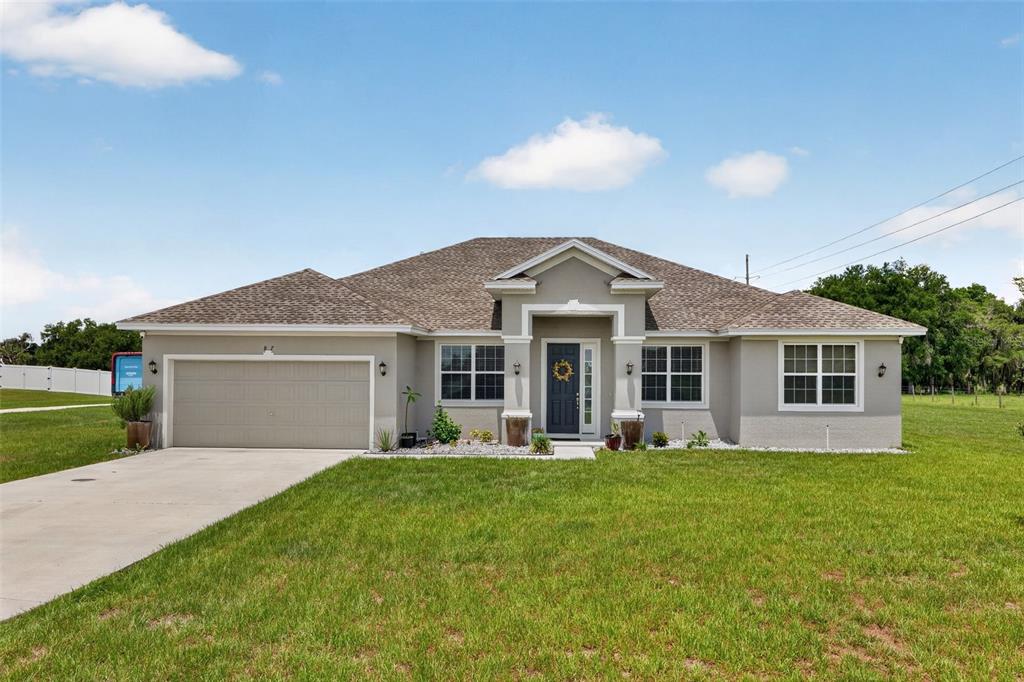 A single-story house with a gray stucco exterior, a two-car garage, and a front porch — 837 LIAM LANE, BARTOW, FL