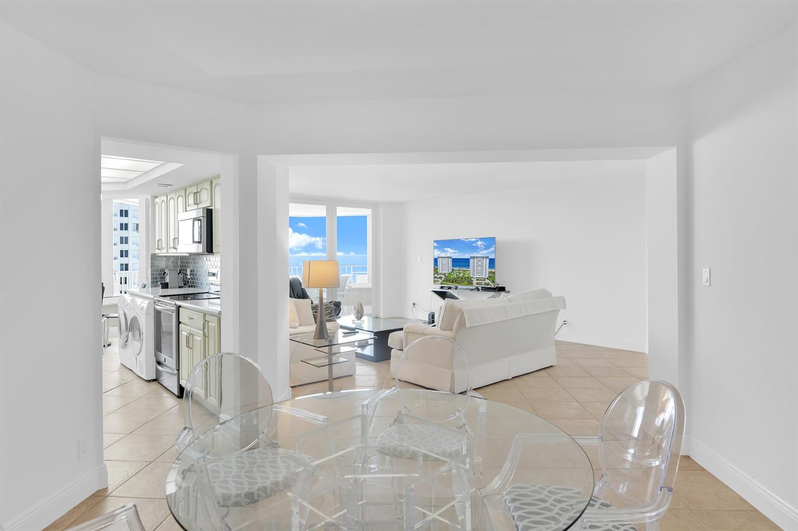 A bright, open-concept living area features a kitchen, dining space, and ocean view balcony — 550 S Ocean Boulevard # 1003, Boca Raton FL 33432, BOCA RATON, FL