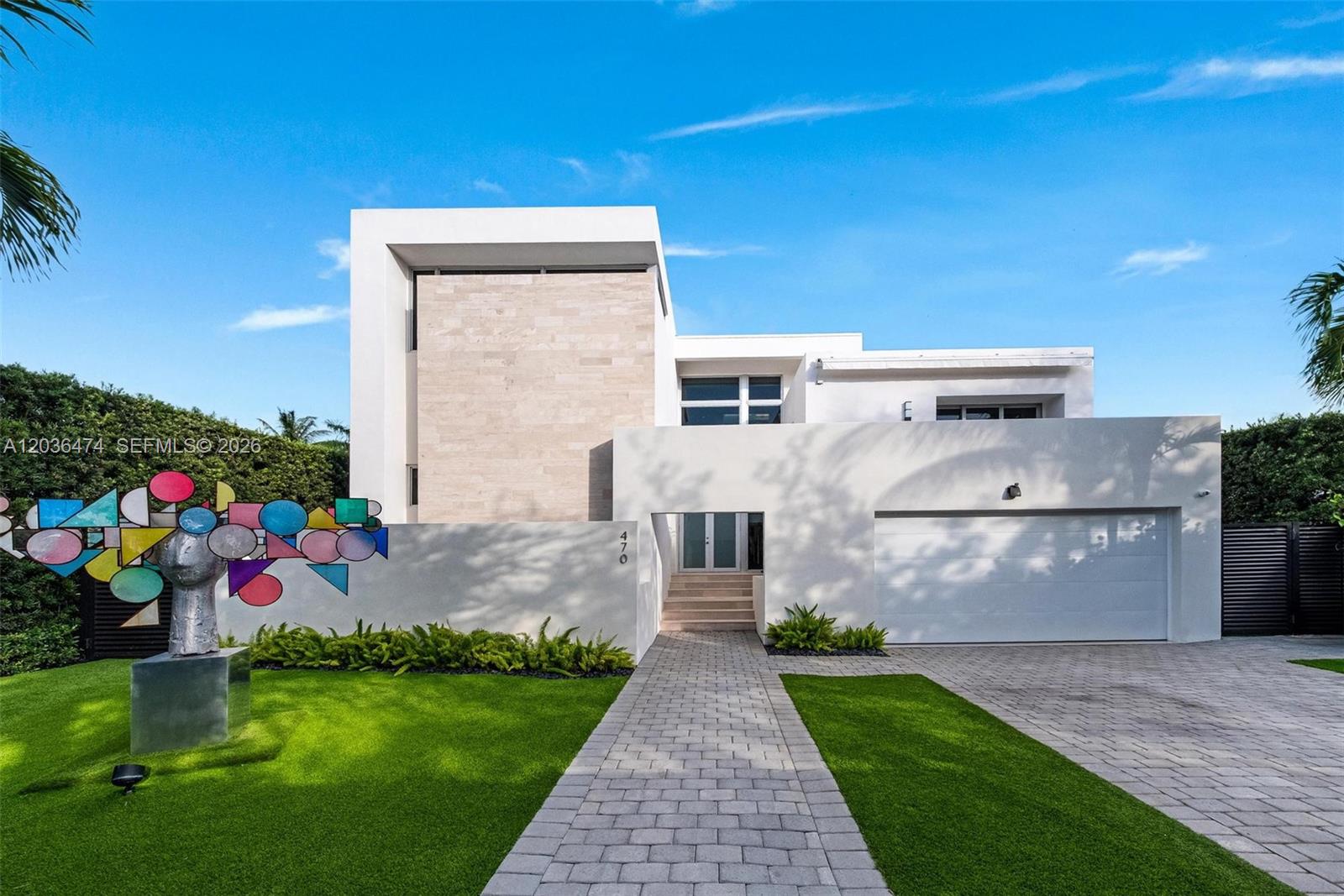 A modern two-story house features a white facade, stone accents, and a colorful abstract sculpture — 470 S Shore Dr, Miami Beach FL 33141, MIAMI BEACH, FL