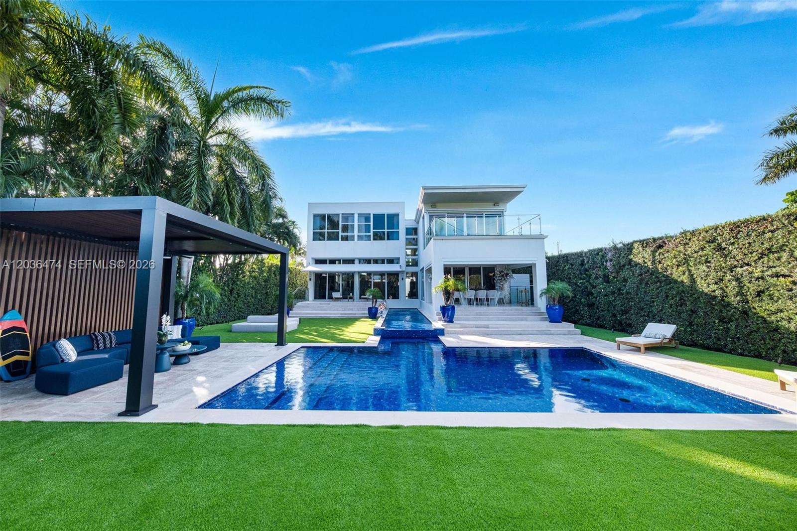 A modern two-story house features a swimming pool, a covered patio, and manicured landscaping — 470 S Shore Dr, Miami Beach FL 33141, MIAMI BEACH, FL