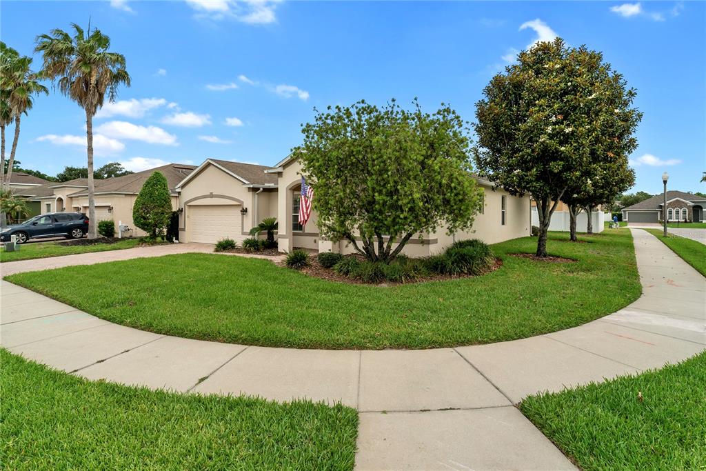 A single-story house with a beige exterior, a two-car garage, and a manicured front lawn — 729 MEADOW GLADE DRIVE, WINTER GARDEN, FL
