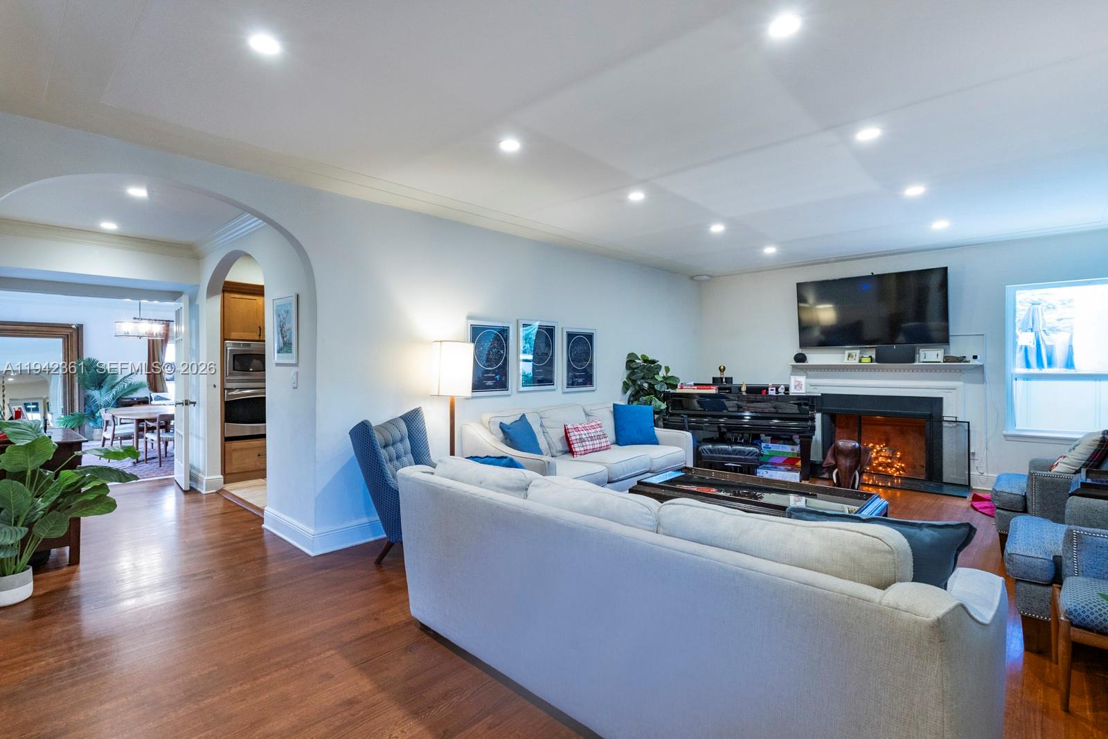 A living room features a fireplace, a piano, and a sofa facing a television — 360 SW 28th Rd, Miami FL 33129, MIAMI, FL