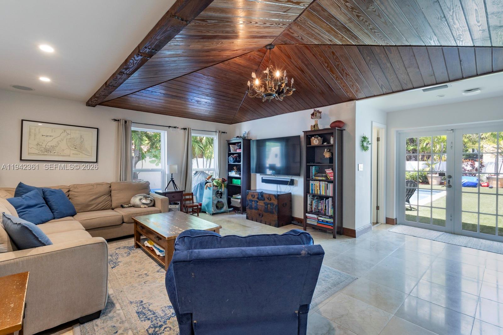 A living room features a vaulted wood-paneled ceiling, a sectional sofa, and a glass door — 360 SW 28th Rd, Miami FL 33129, MIAMI, FL