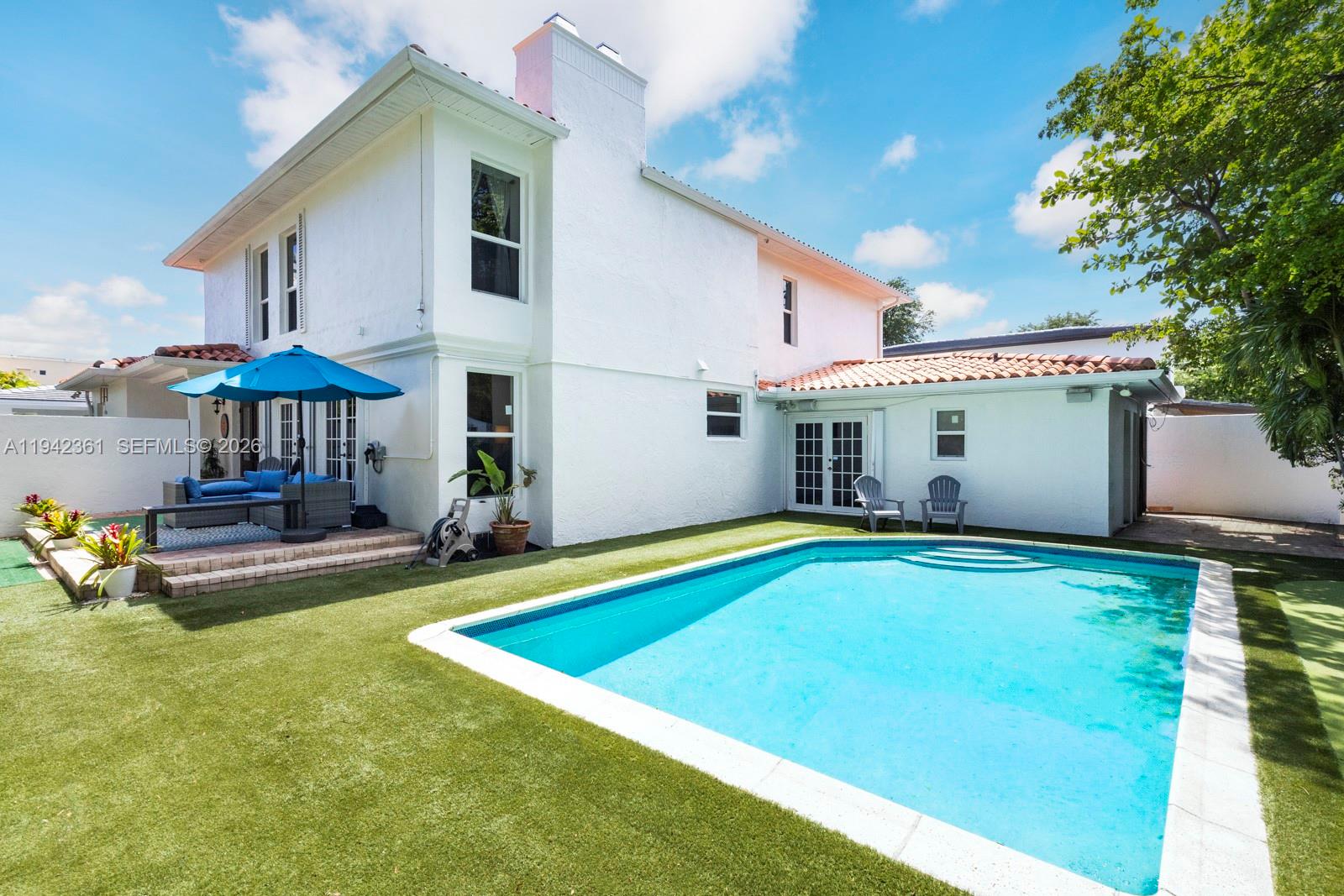 A two-story white house features a swimming pool, artificial turf, and a patio with furniture — 360 SW 28th Rd, Miami FL 33129, MIAMI, FL