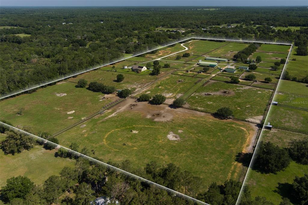 An aerial view shows a large rural property with multiple barns, pastures, and a house — 11130/11122 W HIGHWAY 326, OCALA, FL