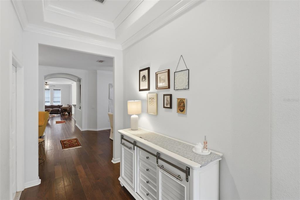 A white console table sits in a hallway with hardwood floors and a gallery wall — 9552 PICCADILLY SKY WAY, ORLANDO, FL