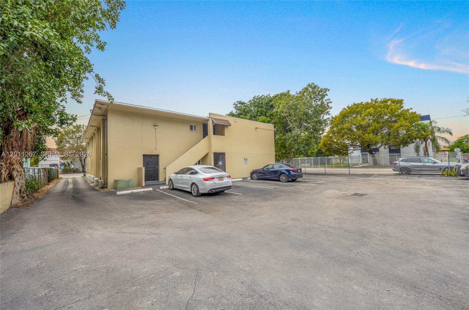 A beige two-story building features an exterior staircase and a paved parking lot — 1 NE 78th St, Miami FL 33138, MIAMI, FL