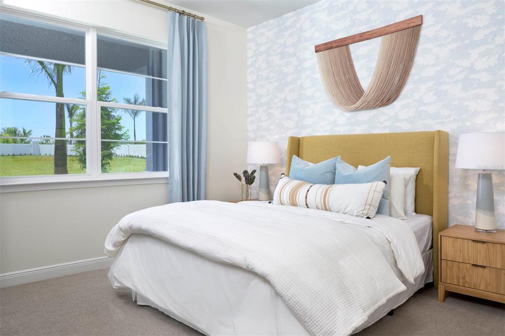 A bedroom features a mustard headboard, blue patterned wallpaper, and a window with blue curtains — 11811 STARBRIGHT PATH, VENICE, FL