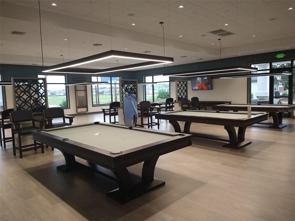 A game room features two pool tables, modern rectangular light fixtures, and large windows — TBD SE 58TH AVENUE, OCALA, FL