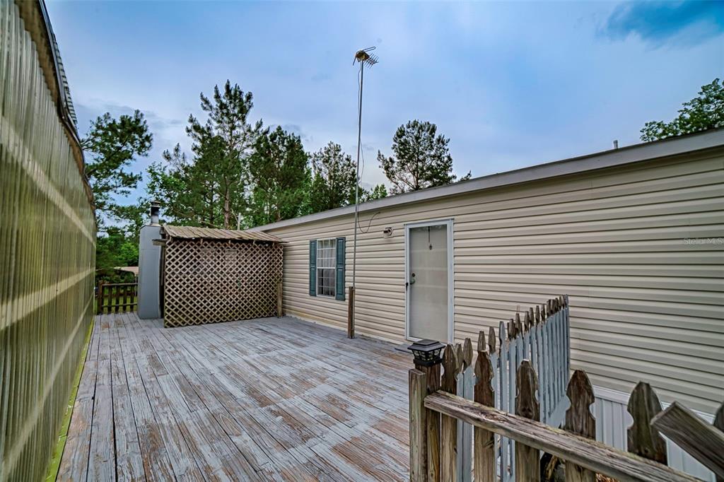 A wooden deck with a lattice privacy screen sits beside a mobile home exterior — 7776 SE 113TH COURT, JASPER, FL