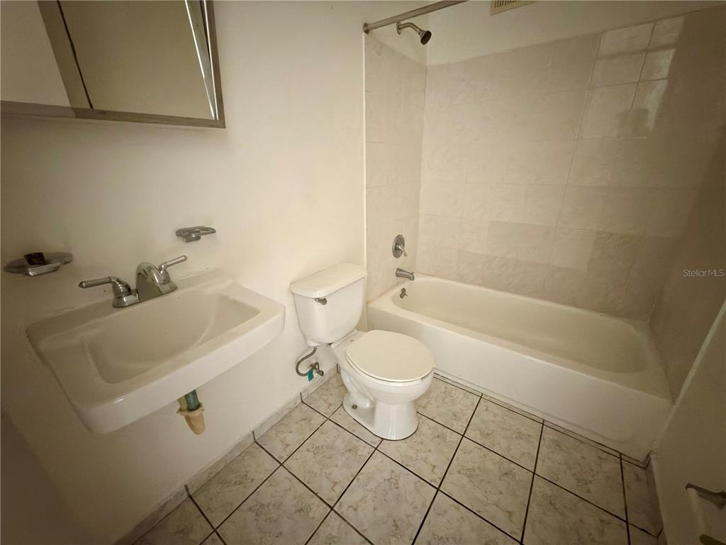 A bathroom features a wall-mounted sink, a white toilet, and a tiled shower-tub combination — 2 CALLE UNIT 227, TRUJILLO ALTO, PR