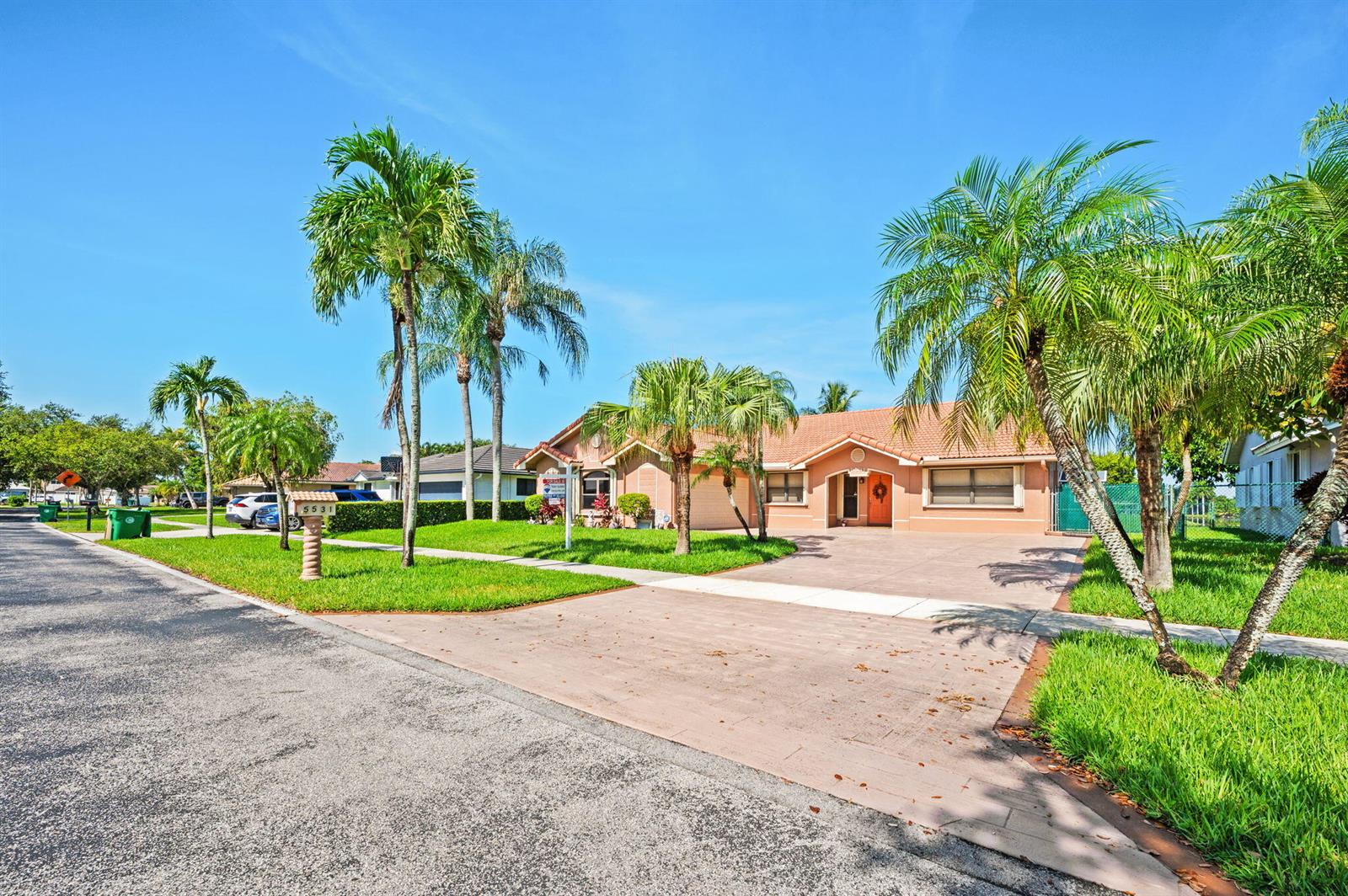 A single-story house with a paved driveway, palm trees, and a tan exterior — 5531 Hawkes Bluff Avenue, Davie FL 33331, DAVIE, FL