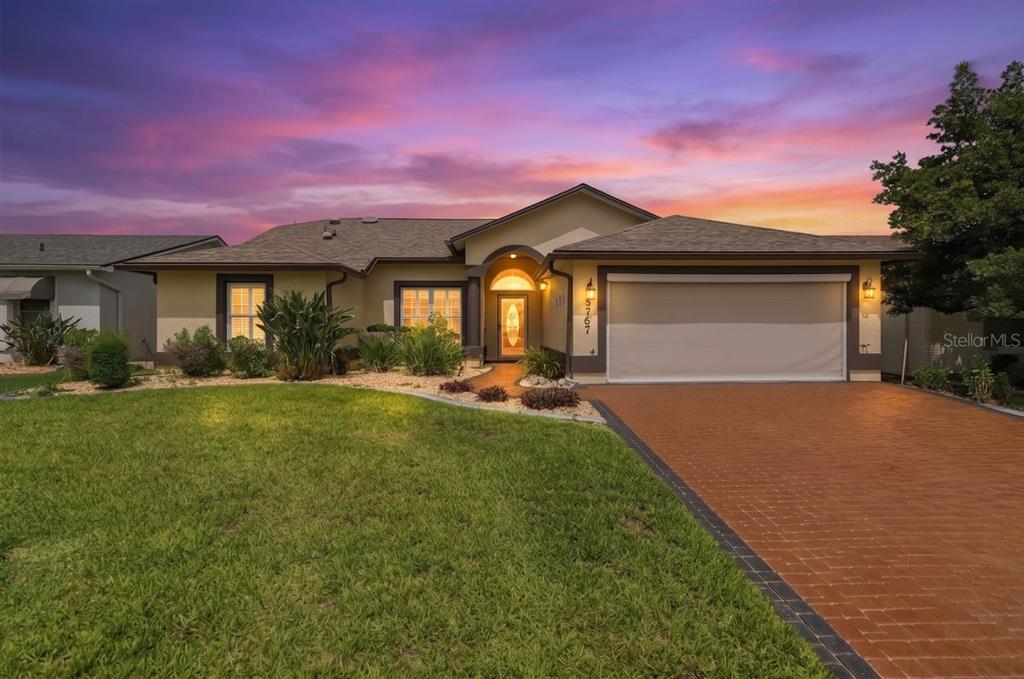 A covered entryway features a brick floor, a wood-paneled ceiling, and a glass-paneled front door — 5767 SANDPIPERS DRIVE, LAKELAND, FL
