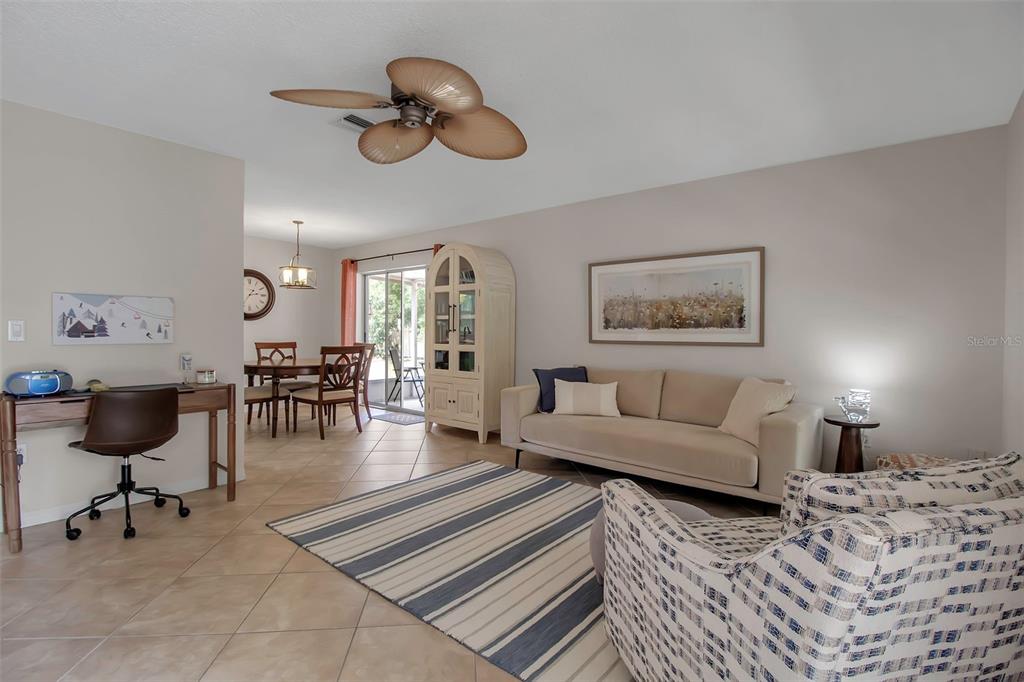 A living room features a beige sofa, a striped rug, and an adjacent dining area — 721 N JEFFERSON AVENUE UNIT 721, SARASOTA, FL