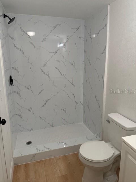 A bathroom features a walk-in shower with white marble-patterned tile and a white toilet — 4605 N HUBERT AVENUE UNIT 21, TAMPA, FL