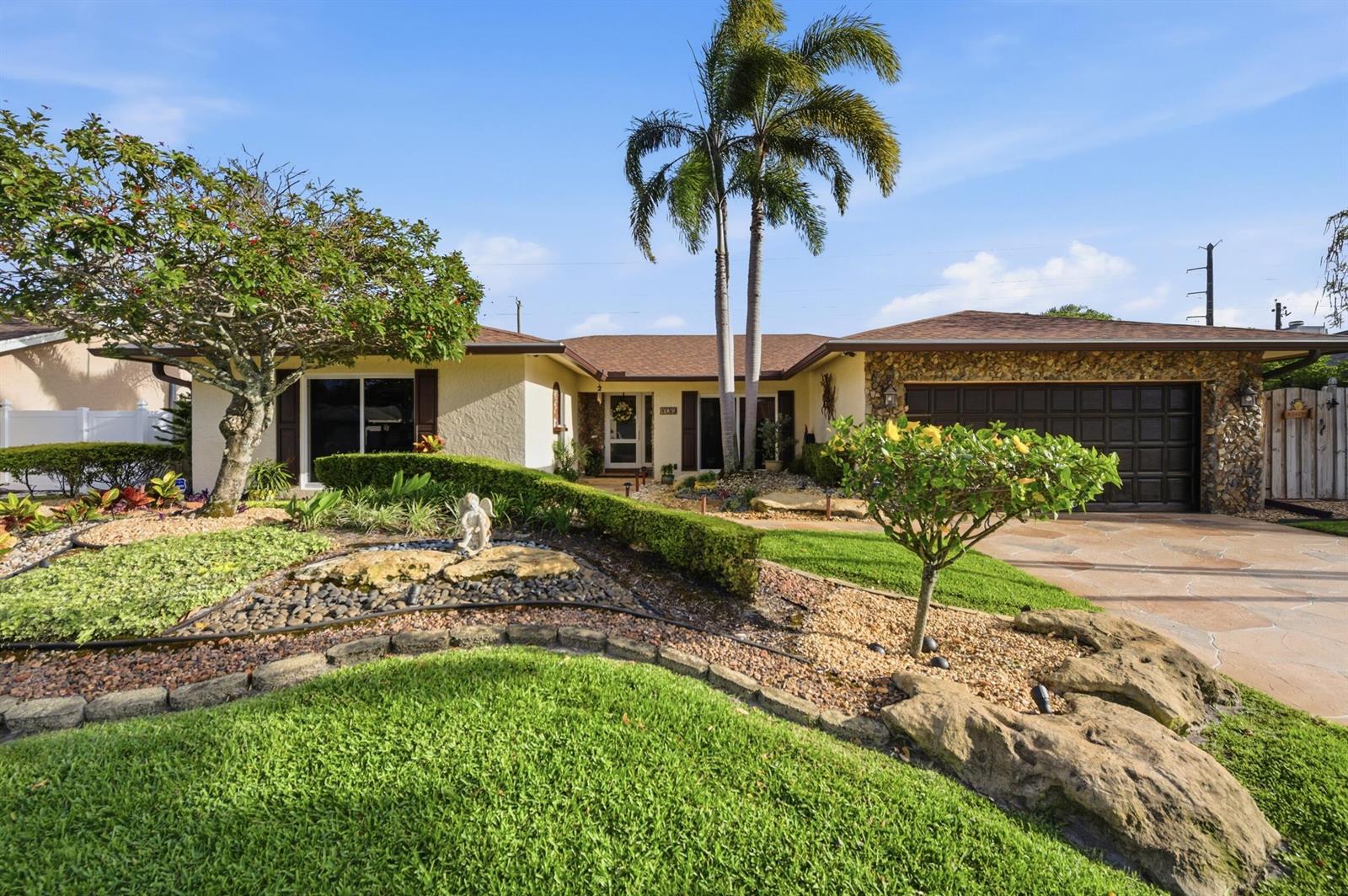 A single-story house with a stone-accented garage, palm trees, and a landscaped front yard — 4780 Brandywine Drive, Boca Raton FL 33487, BOCA RATON, FL
