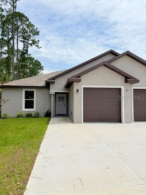 A single-story house with a gray exterior, a brown garage door, and a concrete driveway — 29 SLUMBER PATH UNIT A, PALM COAST, FL