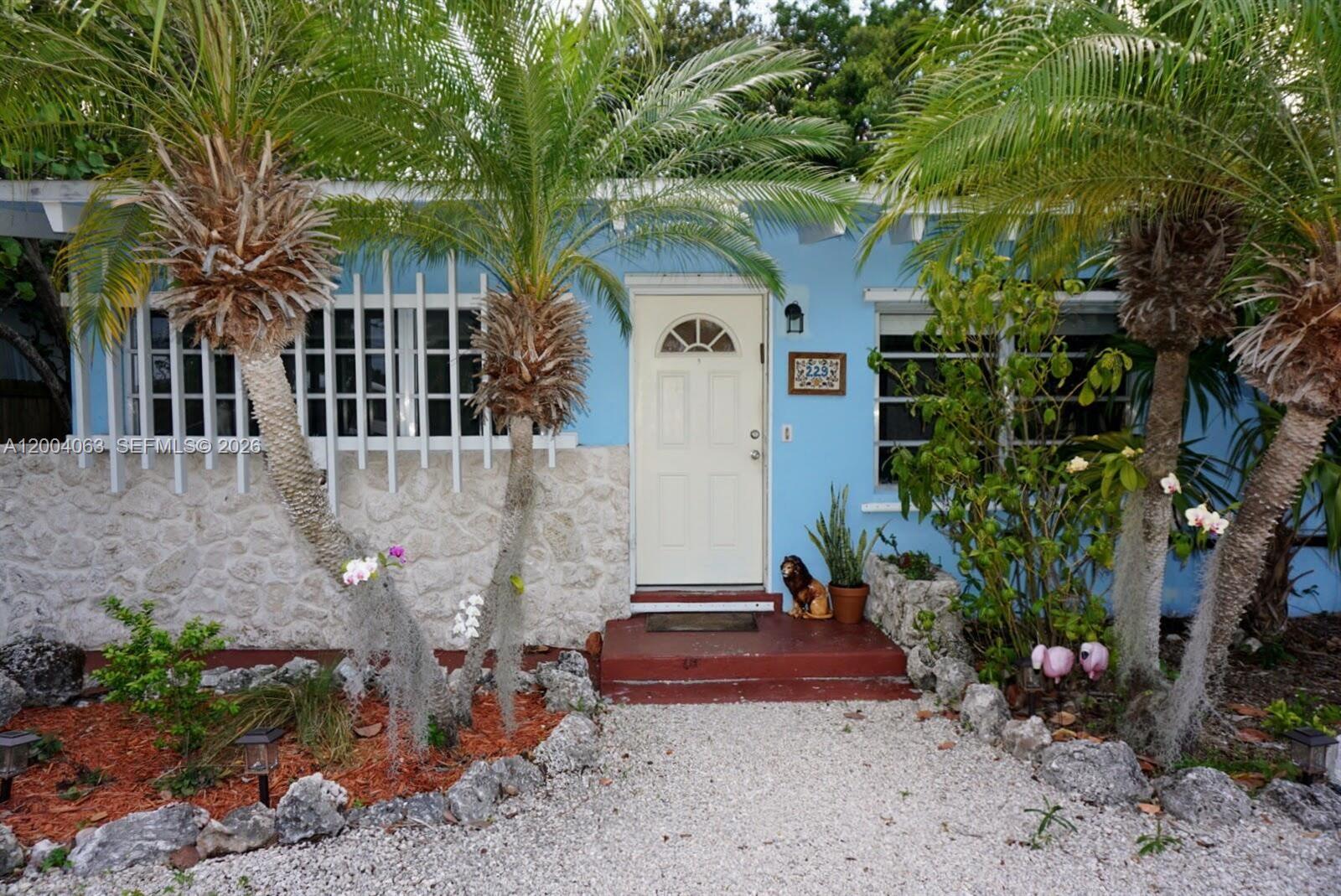 A light blue house with a stone facade, palm trees, and a white front door — 229 2nd Rd, Key Largo FL 33037, KEY LARGO, FL