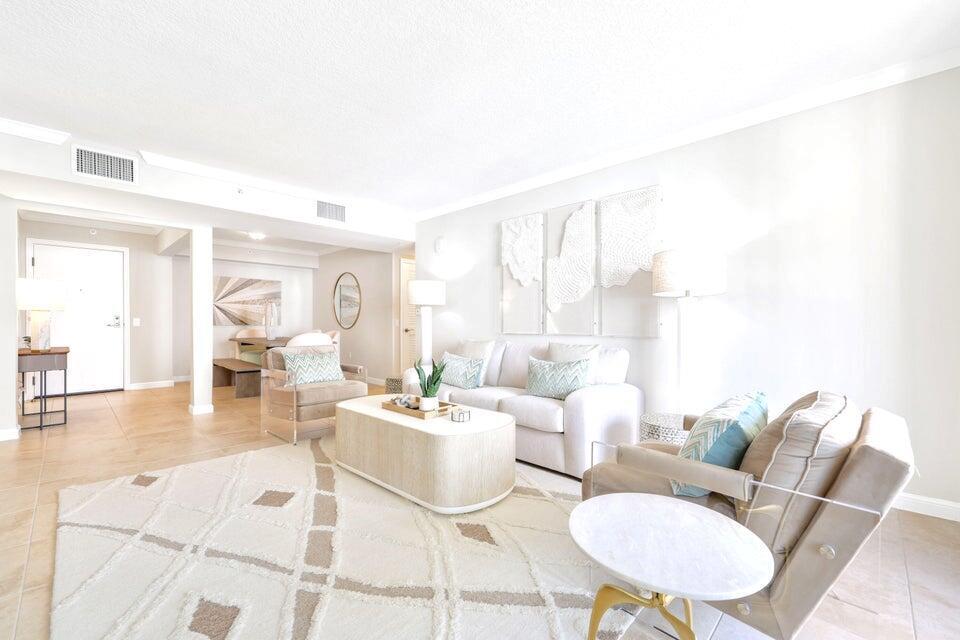 A bright living room features a white sofa, two armchairs, and a textured area rug — 101 Plaza Real S # 606, Boca Raton FL 33432, BOCA RATON, FL