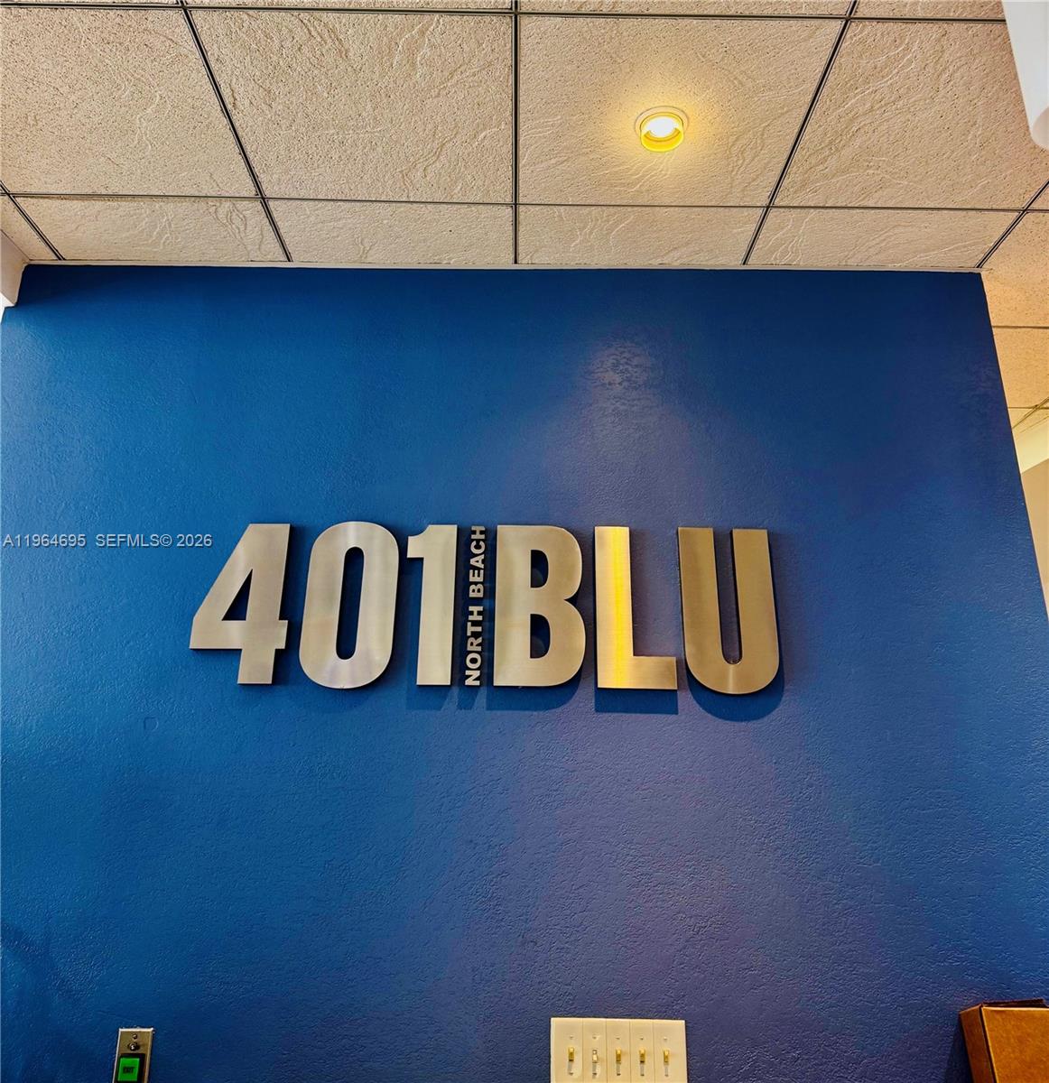 A blue wall features large metallic lettering reading 401 BLU NORTH BEACH — 401 N 69th St # 607, Miami Beach FL 33141, MIAMI BEACH, FL
