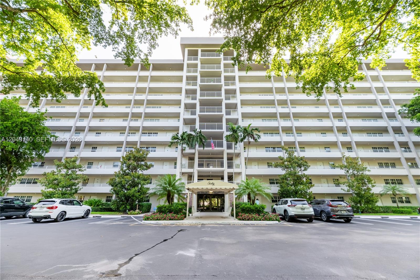 A multi-story apartment building with a covered entrance and parking lot in front — 605 Oaks Dr # 607, Pompano Beach FL 33069, POMPANO BEACH, FL