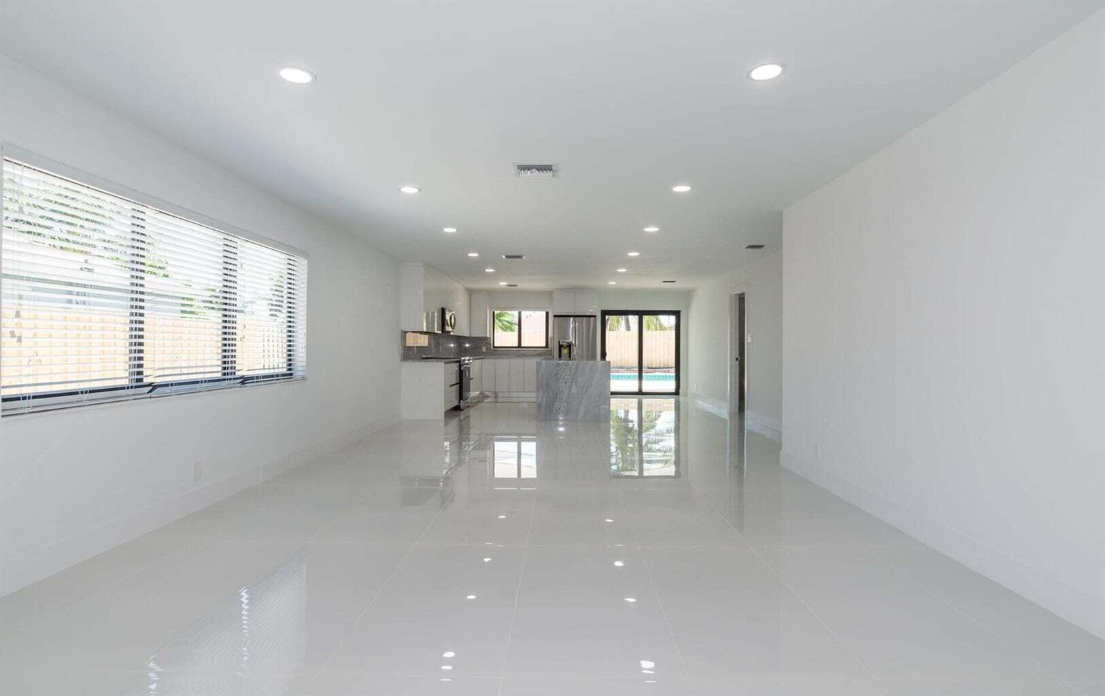 A bright, open-concept kitchen and living area features white walls, glossy tile floors, and recessed lighting — 524 NW 53rd Street, Boca Raton FL 33487, BOCA RATON, FL