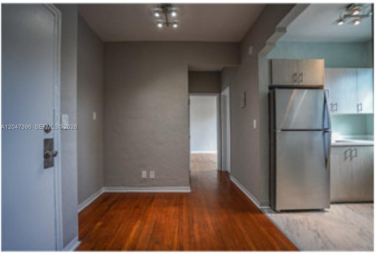 A view of a kitchen area with hardwood floors, a stainless steel refrigerator, and cabinets — 715 Michigan Ave # 7, Miami Beach FL 33139, MIAMI BEACH, FL