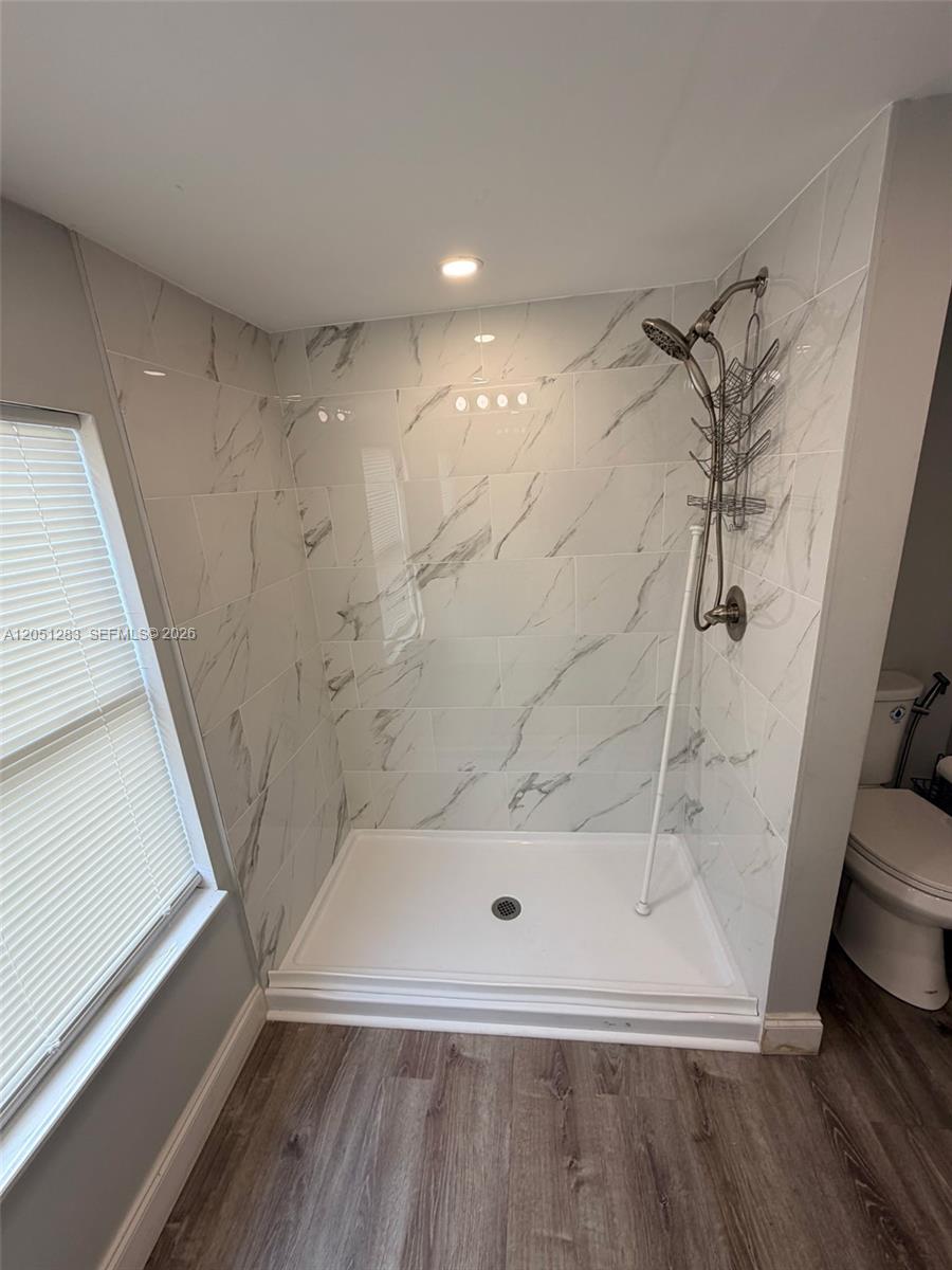 A walk-in shower with white marble-patterned tile walls and a glass enclosure — 3707 SE 27th St, Okeechobee FL 34974, OKEECHOBEE, FL