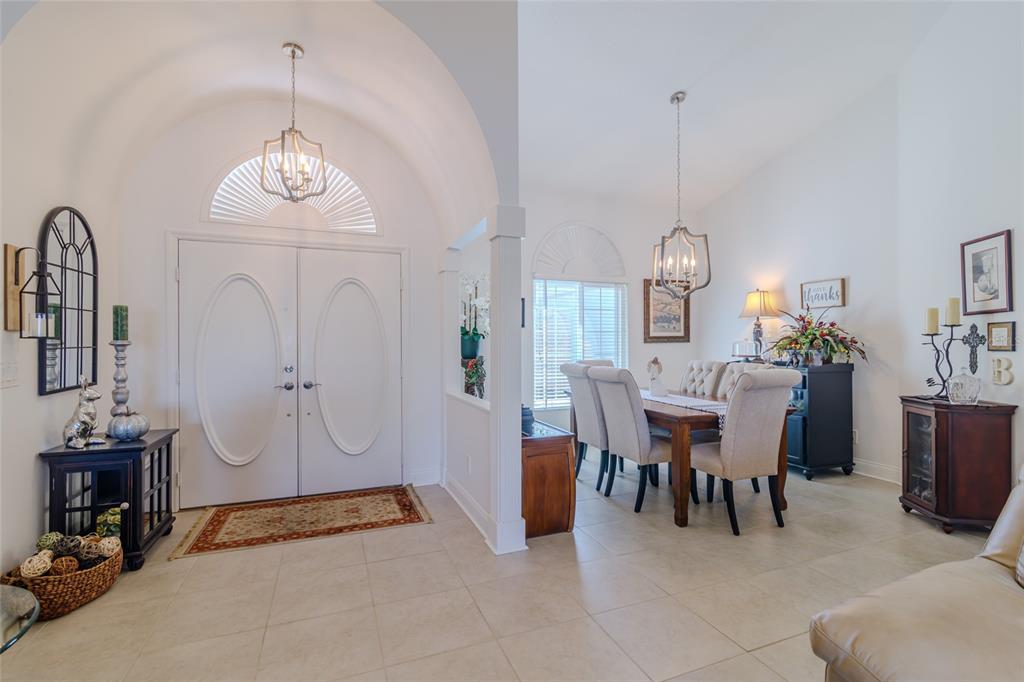 A bright entryway with a vaulted ceiling leads into a dining room with tiled floors — 1956 NW 50TH CIRCLE, OCALA, FL