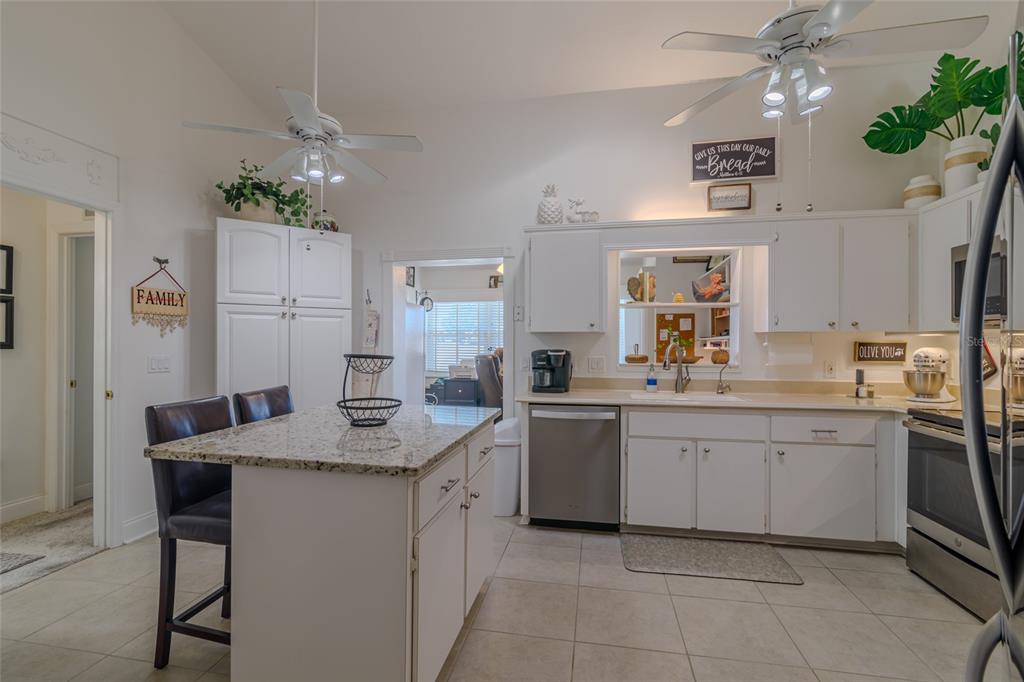 A kitchen with white cabinets, granite countertops, a center island, and stainless steel appliances — 1956 NW 50TH CIRCLE, OCALA, FL