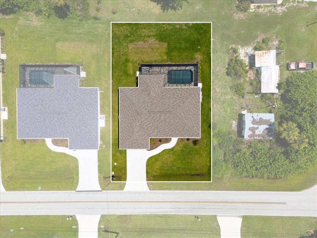 An aerial view shows a single-family home with a screened pool on a grassy lot — 9171 PROSPECT AVENUE, ENGLEWOOD, FL