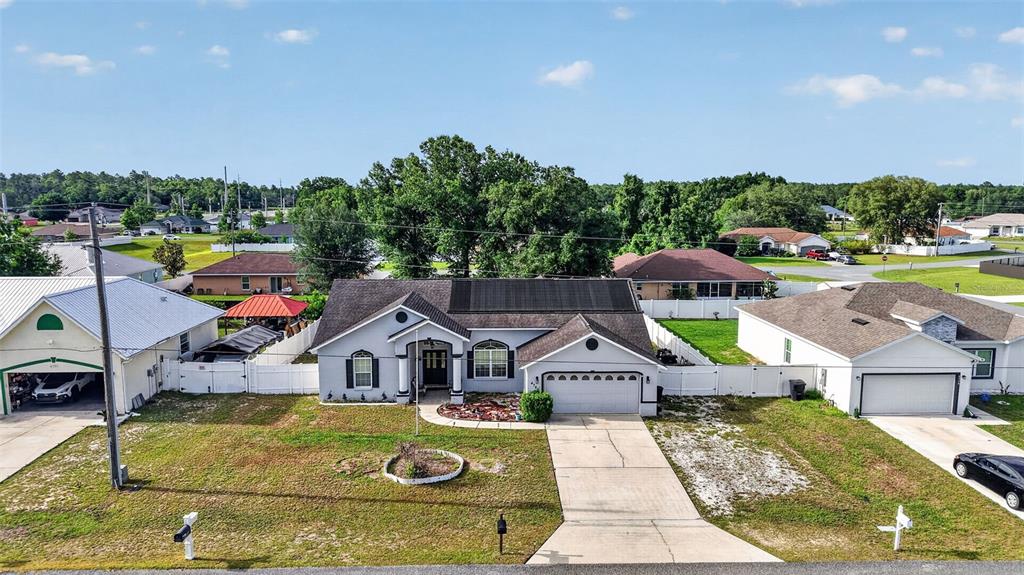 An aerial view of a single-story suburban house with solar panels on the roof — 4783 SW 131ST PLACE, OCALA, FL