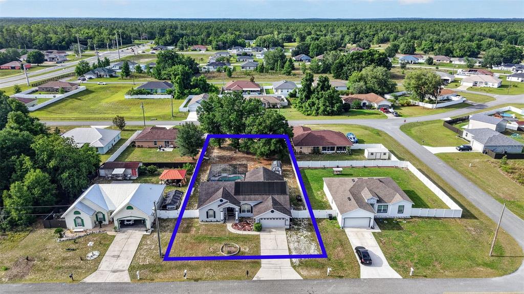 An aerial view shows a single-story house with a pool and fenced backyard — 4783 SW 131ST PLACE, OCALA, FL