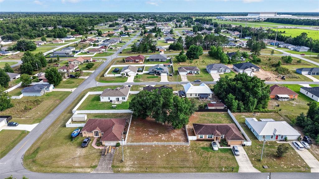 An aerial view shows a vacant residential lot situated between two houses in a neighborhood — 4783 SW 131ST PLACE, OCALA, FL