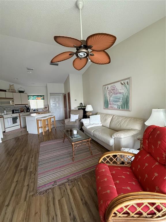 A living room features a palm-leaf ceiling fan, a beige sofa, and a red armchair — 5435 CASABLANCA CIRCLE UNIT M22, SEBRING, FL