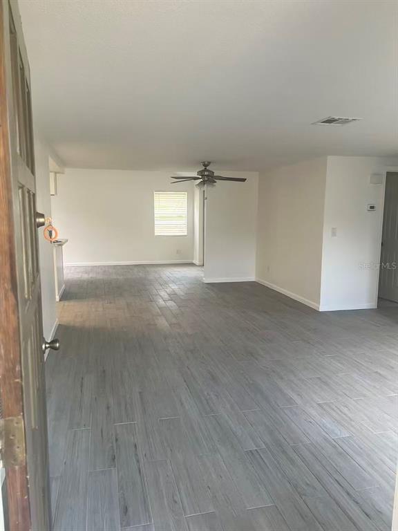 An open-concept living area features light gray wood-look tile flooring and a ceiling fan — 8516 INWOOD DRIVE, HUDSON, FL
