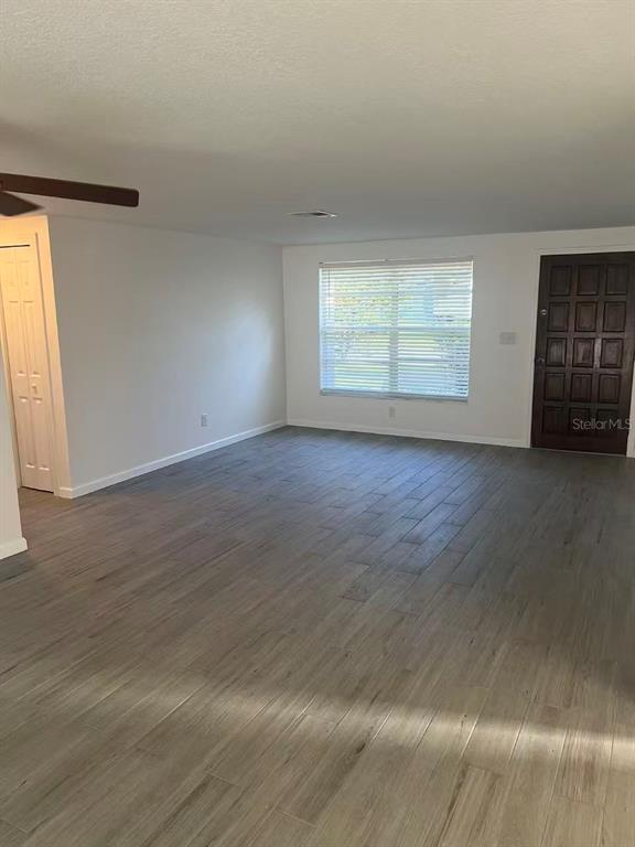 An empty room features light gray wood-look tile flooring, white walls, and a single window — 8516 INWOOD DRIVE, HUDSON, FL