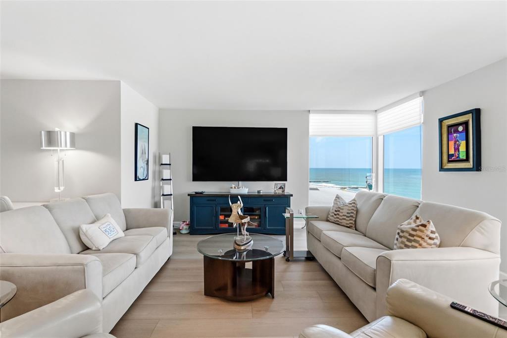 A living room features two beige sofas, a glass coffee table, and a blue media console — 2425 GULF OF MEXICO DRIVE UNIT 7C, LONGBOAT KEY, FL