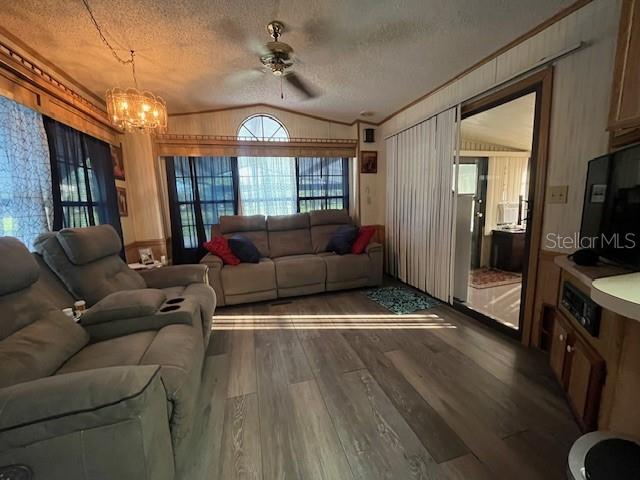 A living room features light wood-look flooring, a gray reclining sofa, and a matching loveseat — 70 FAIRVIEW DRIVE S, HAINES CITY, FL