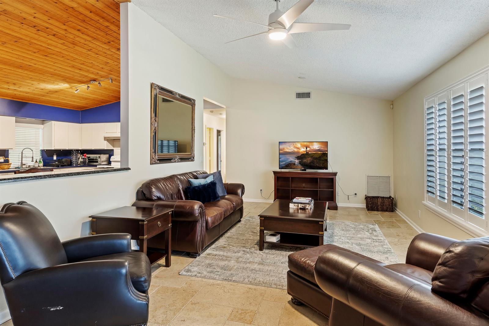 A living room features leather furniture, a coffee table, a television, and tile flooring — 756 Juniper Place, Wellington FL 33414, WELLINGTON, FL